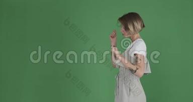 害羞的女人在绿色屏幕上逆转她的舞步